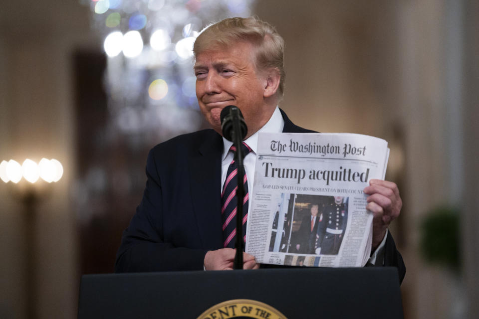 President Donald Trump holds up a newspaper trumpeting his acquittal as he spoke in the East Room of the White House on Thursday. (Photo: ASSOCIATED PRESS)