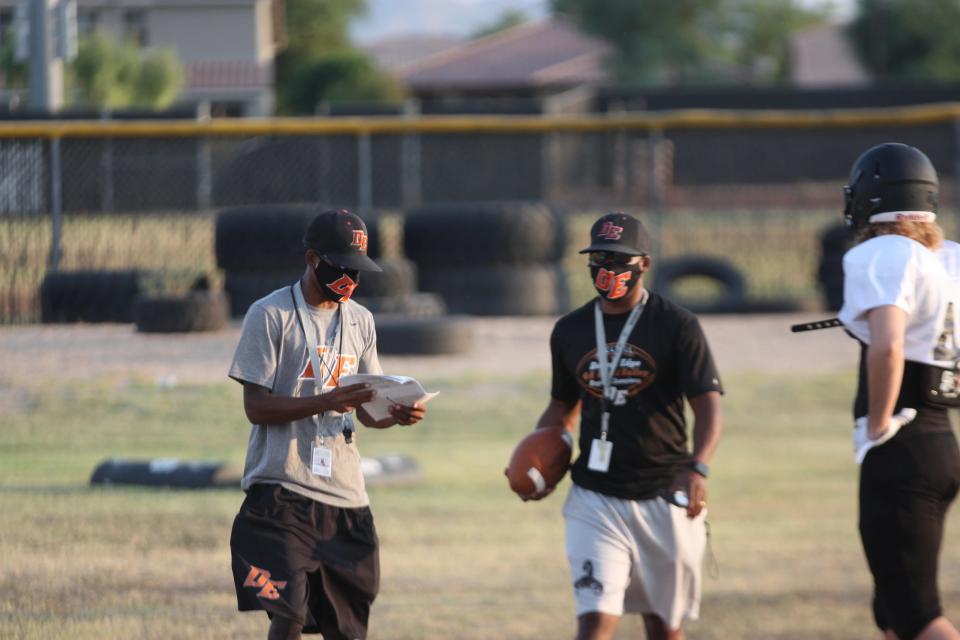 Desert Edge football co-head coaches Mark Carter (left) and Marcus Carter (middle) direct plays during a team practice.