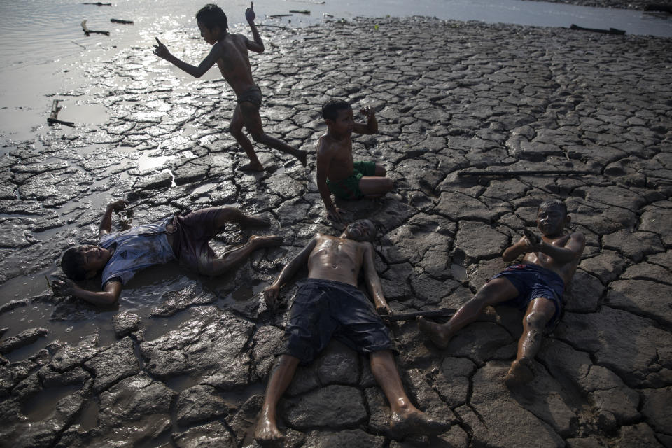 Children play a game of soldiers on the banks of the Ucayali River in Palestina, in Peru's Ucayali region, Peru, Wednesday, Sept. 30, 2020. The Ucayali region located along a muddy river has long seen periodic dengue outbreaks, though this year's figures are already three times that seen in 2019. (AP Photo/Rodrigo Abd)