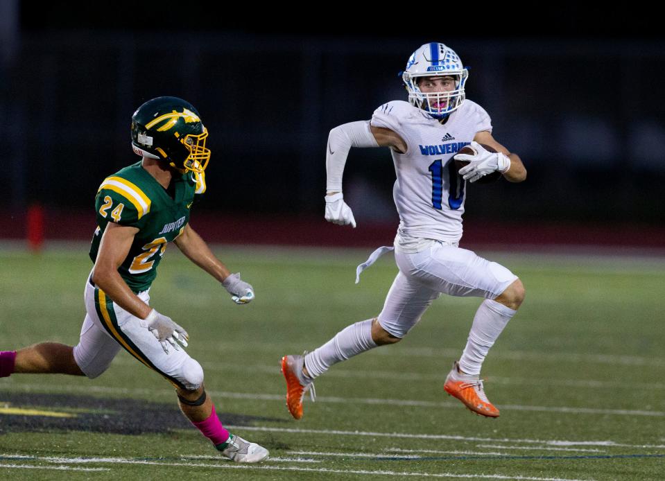 Wellington wide receiver Reece Larson runs past Jupiter's Landon Carr during their game in Jupiter on Oct. 16.