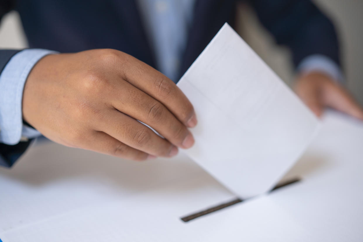 Male hand inserting ballot