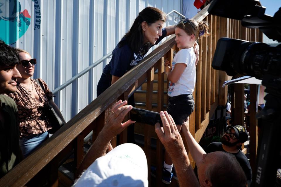 Former South Carolina Governor and Ambassador to the United Nations Nikki Haley speaks with a young fairgoer on Aug. 12.<span class="copyright">Chip Somodevilla—Getty Images</span>