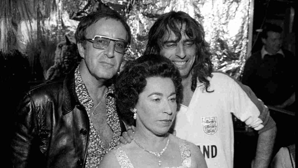 Alice Cooper with Peter Selllers and Queen Elizabeth II impersonator Jeanette Charles in London in 1975