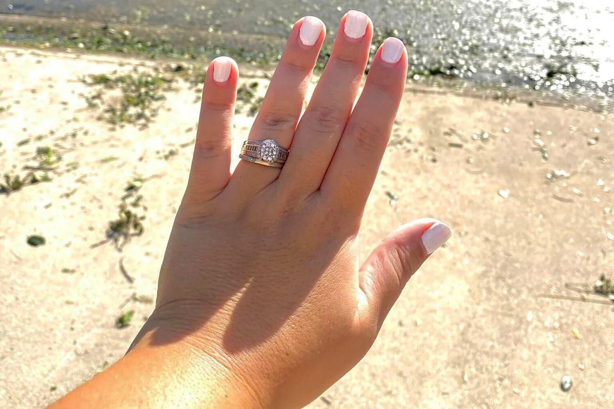 In this undated photo provided by Ashley Garner, Garner shows off her wedding ring that was found lying in a brush pile after Hurricane Ian passed through the area, in Fort Myers, Fla.