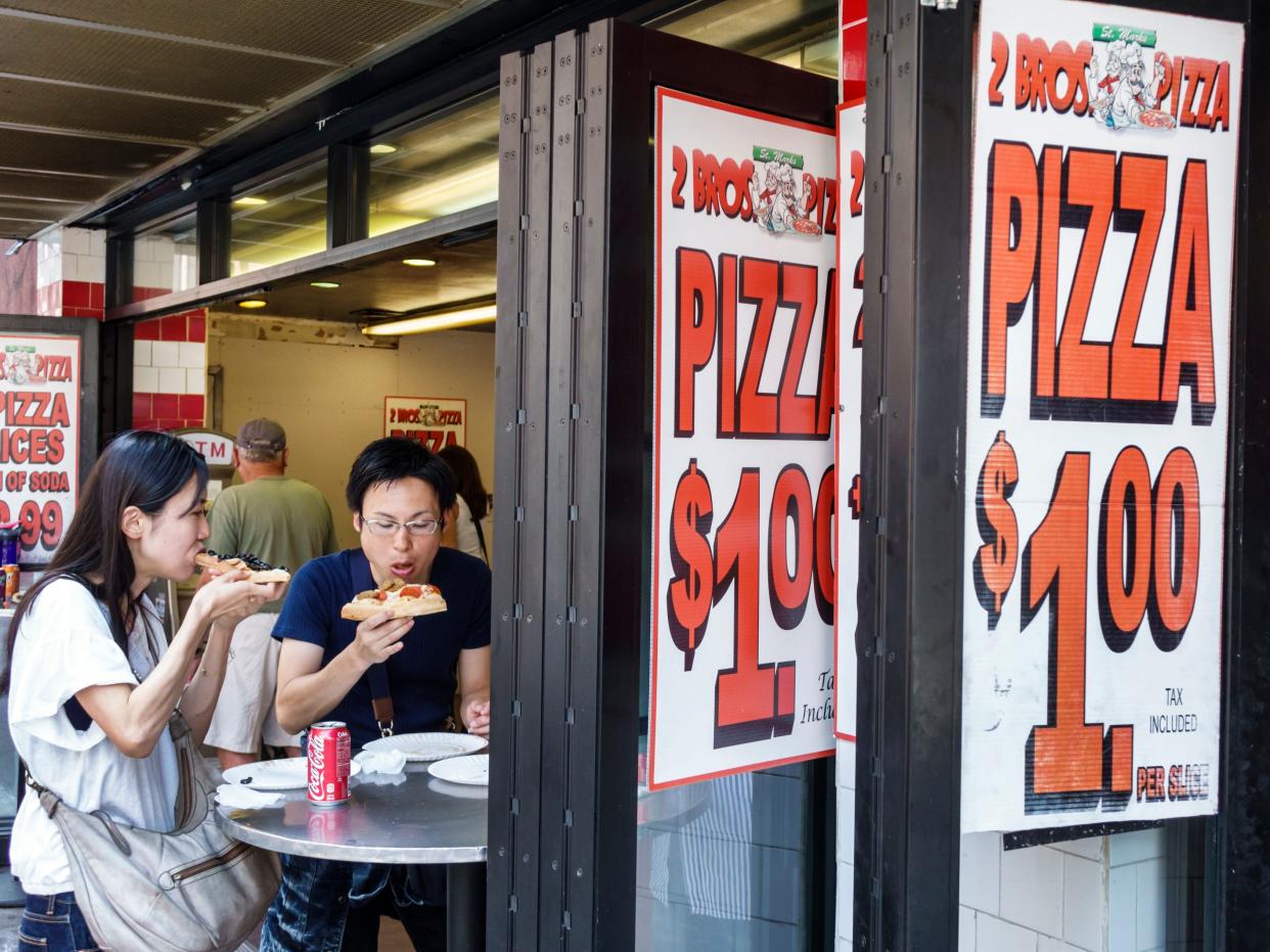 A couple eating pizza at 2 Bros Pizza.