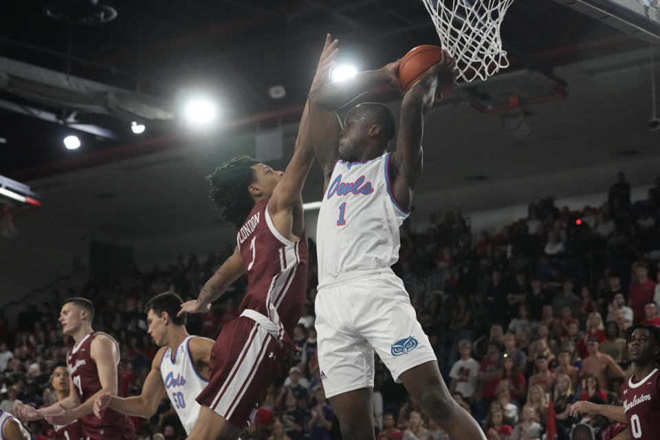 Florida Atlantic guard Johnell Davis (1) grabs a rebound over Charleston guard Khalil London (3) during the second half of an NCAA college basketball game, Saturday, Dec. 2, 2023, in Boca Raton, Fla. Florida Atlantic defeated Charleston 90-74. (AP Photo/Marta Lavandier)