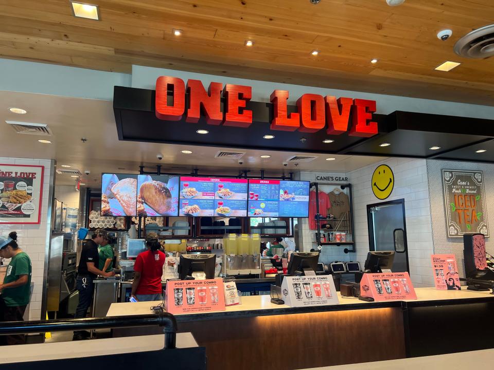 Raising Cane's registers with "One Love" sign above it