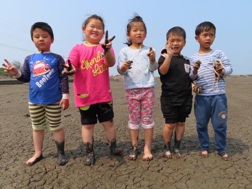 北門雙春國小附幼小朋友，前往魚塭探索尋寶，儘管腳上沾滿爛泥也無所謂。(記者盧萍珊攝)