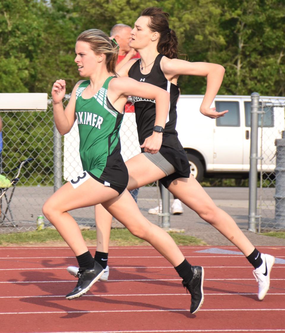 Herkimer's Morgan Berberick (left) passes Madelyn Schultz from Onondaga in the sprint to the finish of the 400-meter hurdles at Section III's Class C-1 track and field championship meet.