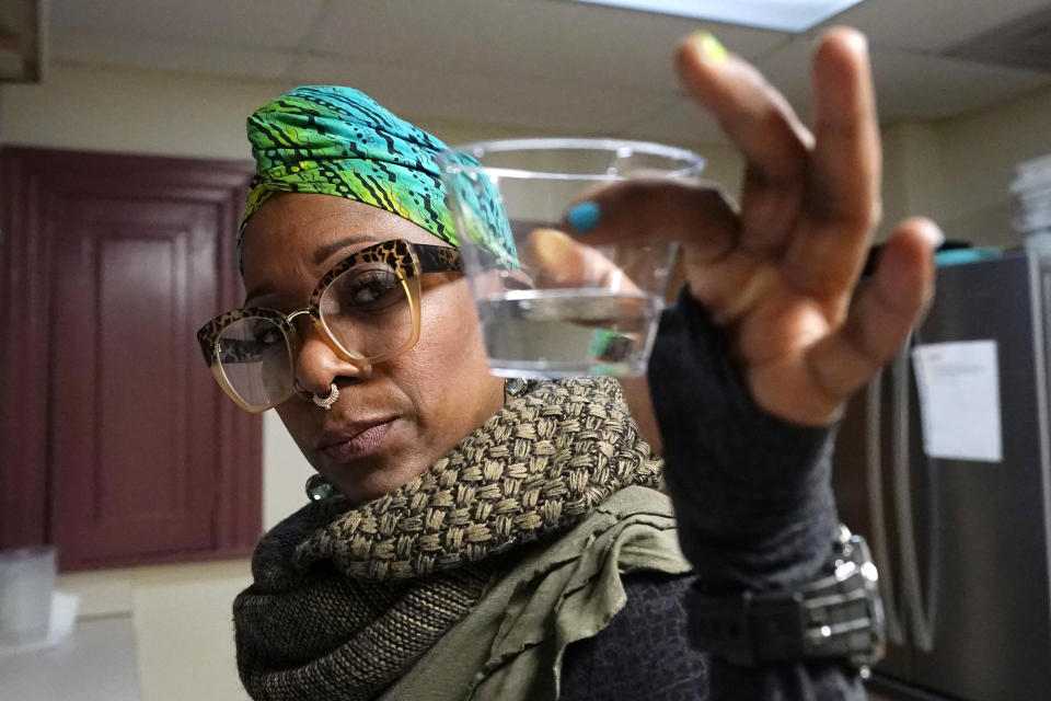 Angela Stamps holds a sampling of tap water, Thursday, Jan. 6, 2022, in Flint, Mich. After Flint's water crisis, 35% of Black adults in the U.S. said they didn't drink tap water, up from 25%. High-profile cases of lead contamination in predominantly Black cities and a history of deception around the problem have led to a distrust of tap water, which can have long-term health and financial consequences. (AP Photo/Carlos Osorio)