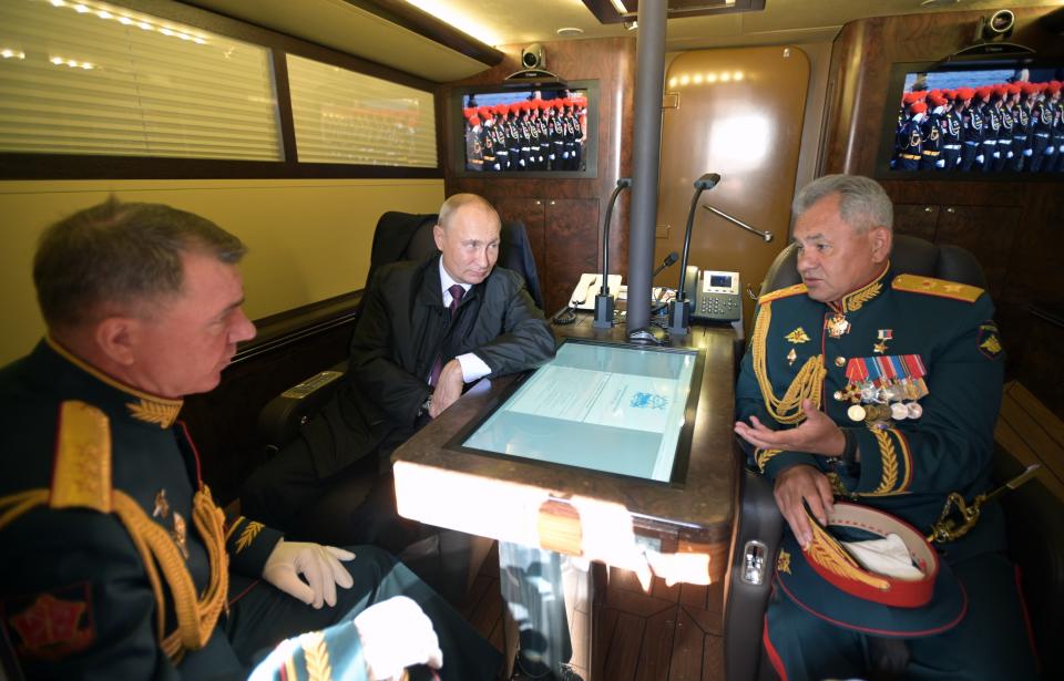 Russian President Vladimir Putin, center, and Defense Minister Sergei Shoigu, right, with Chief of the Main Military-Political Directorate of the Russian Armed Forces Gen. Col. Alexander Zhuravlev, left, as they talk aboard a ship, on their way to attend a military parade during the Navy Day celebration in Kronshtadt outside St.Petersburg, Russia, Sunday, July 26, 2020. (Alexei Druzhinin, Sputnik, Kremlin Pool Photo via AP)