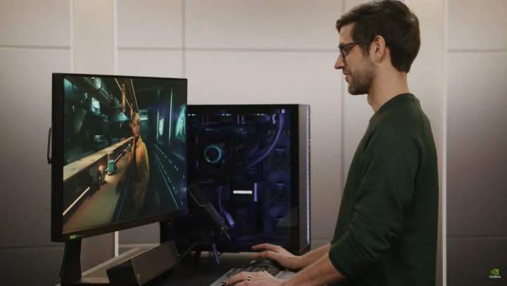 A man stands in front of a gaming PC.