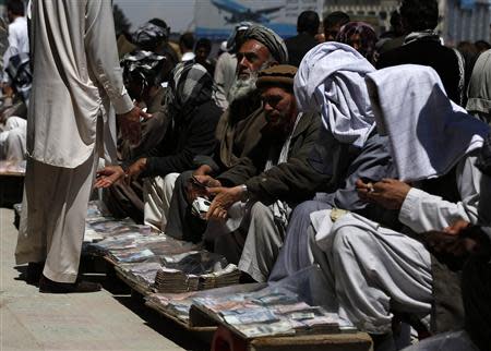 Afghan money changers offer Afghanis for sale at Kabul's largest money market April 23, 2014. REUTERS/Omar Sobhani