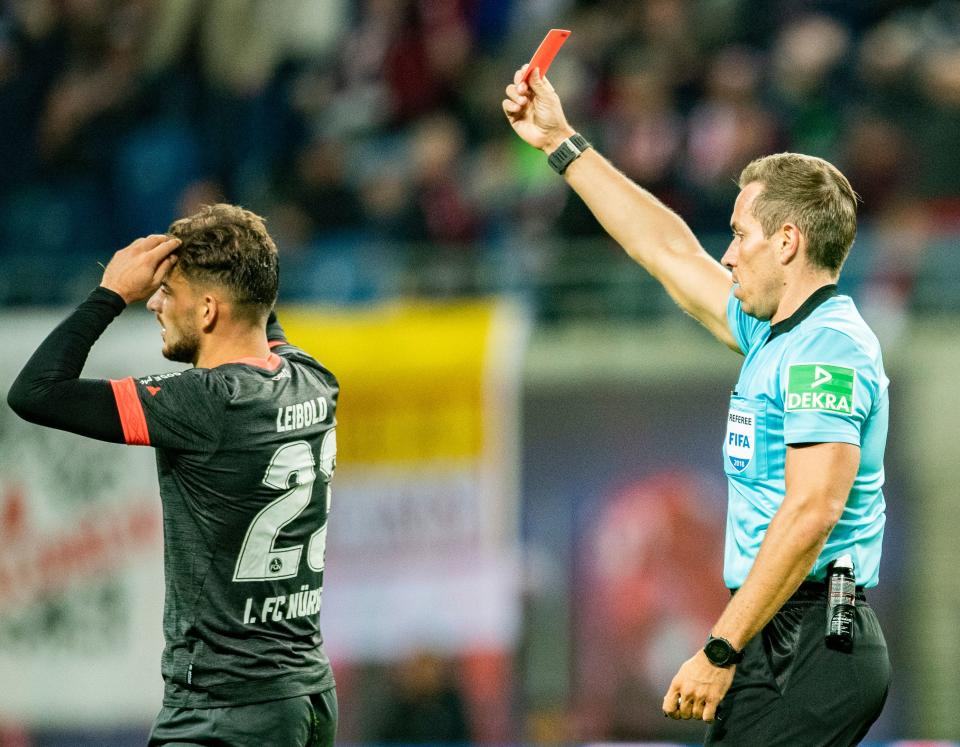 A referee brandishes a red card, this time not at himself.