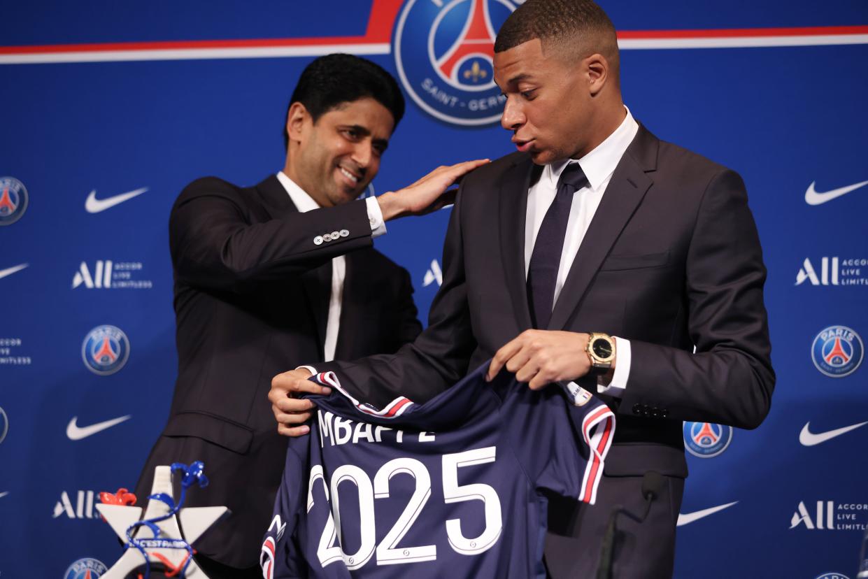 El presidente del Paris Saint-Germain, Nasser Al-Khelaifi, y el delantero francés Kylian Mbappé posan con una camiseta al final de una conferencia de prensa en el estadio Parc des Princes de París el 23 de mayo de 2022, dos días después de que el club ganara el título de la Ligue 1 por décima vez, igualando un récord, y su delantero superestrella Mbappé eligió firmar un nuevo contrato hasta 2025 con el PSG en lugar de unirse al Real Madrid. (Foto; Gao Jing/Xinhua vía Getty Images)