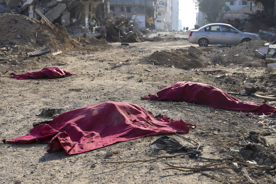 Bodies of Palestinians who were killed in the Israeli bombardment of the Gaza Strip are covered in the main road in Gaza City on Tuesday, Jan. 2, 2024. (AP Photo/Mohammed Hajjar)