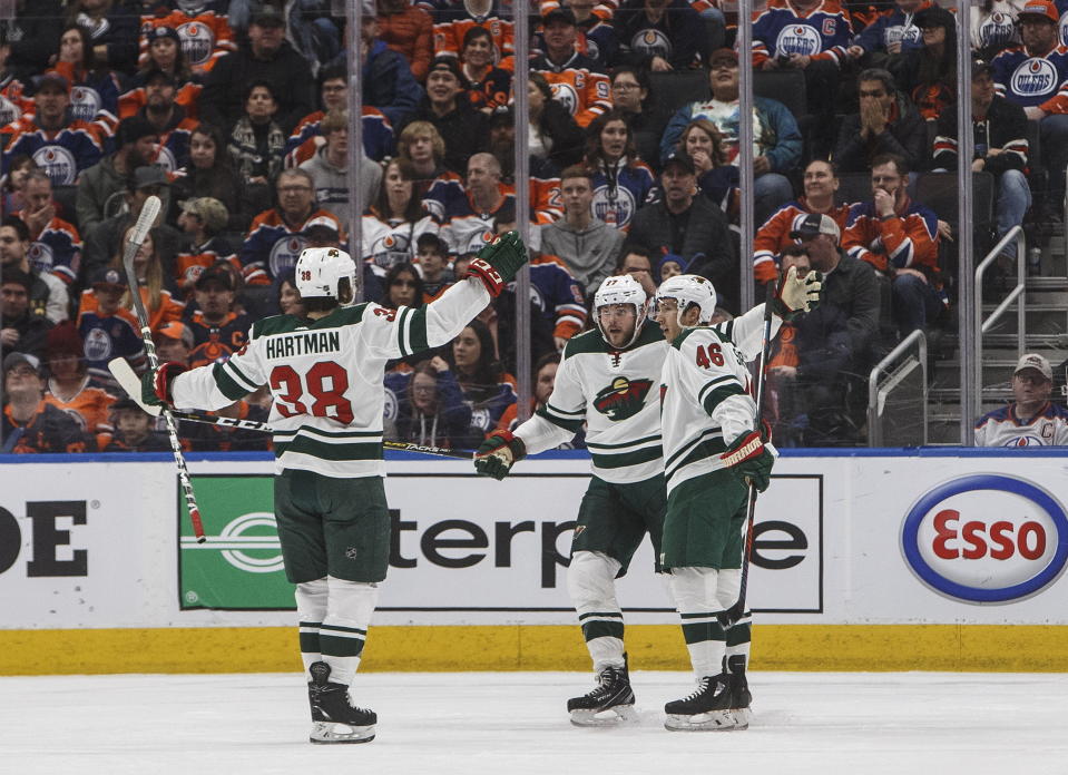 Minnesota Wild's Ryan Hartman (38), Marcus Foligno (17) and Jared Spurgeon (46) celebrate a goal against the Edmonton Oilers during the second period of an NHL hockey game Friday, Feb. 21, 2020, in Edmonton, Alberta. (Jason Franson/The Canadian Press via AP)