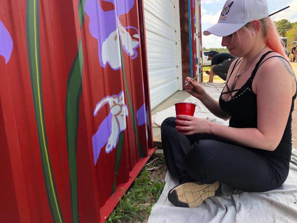 Hollie Hewitt of Columbia volunteered to help Matt Willey and others paint a mural on the Red Wolf Center to highlight the critically endangered animals that live in the wild nowhere but Eastern NC.