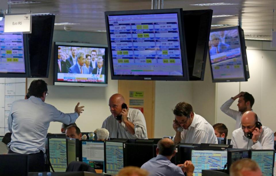 Politician Nigel Farage who backed Britain's leave, is seen on TV as traders in London find themselves in a Frenzy. (Reuters/Russell Boyce)