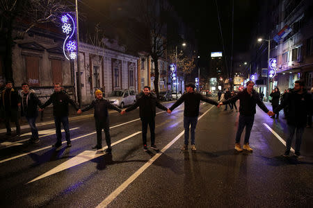 Demonstrators stand along a street during an anti-government protest in central Belgrade, Serbia, December 8, 2018. Thousands rallied peacefully in downtown Belgrade on Saturday to protest the beating of an opposition politician, policies of President Aleksandar Vucic and his ruling Serbian Progressive party. REUTERS/Marko Djurica