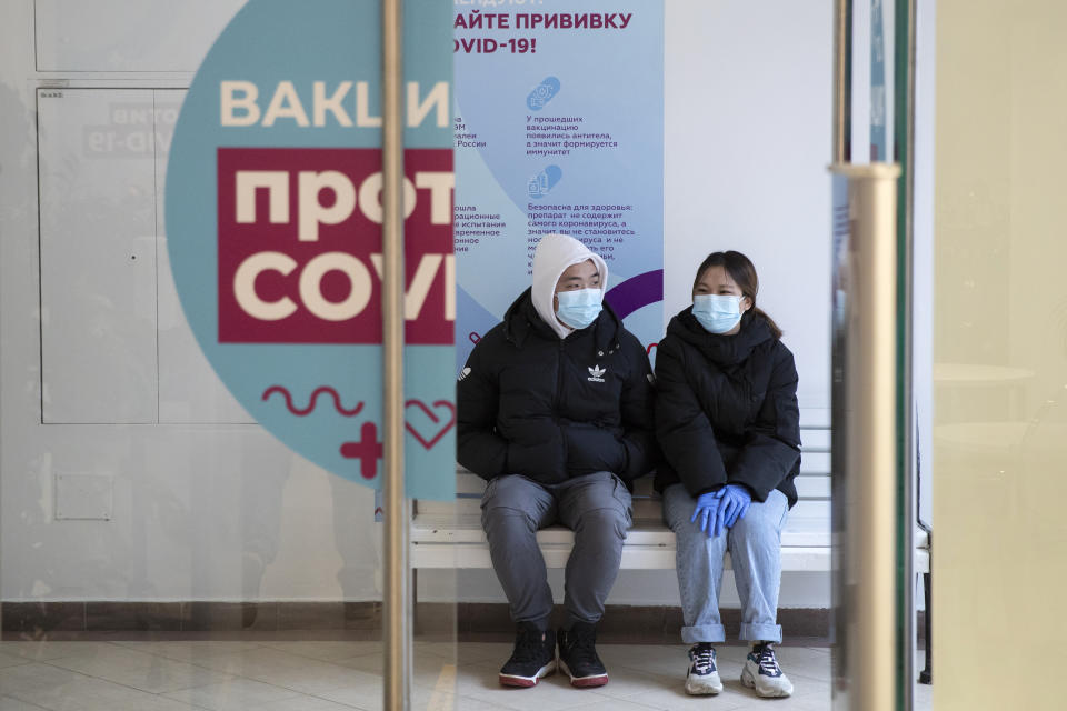 A couple wait in a queue to get a shot of Russia's Sputnik V coronavirus vaccine at a vaccination center in GUM State Department store in Moscow, Russia, Wednesday, Jan. 20, 2021. Russia started a mass coronavirus vaccination campaign on Monday. (AP Photo/Pavel Golovkin)