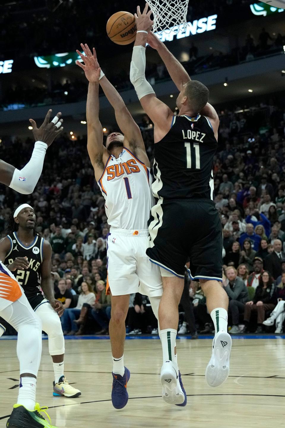 Milwaukee Bucks center Brook Lopez (11) blocks a shot by Phoenix Suns guard Devin Booker (1) in the final seconds of the fourth quarter of the Bucks 104-101 win at Fiserv Forum in Milwaukee on Sunday, Feb. 26, 2023.