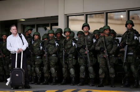 A passenger waits as Brazilian Air force soldiers patrol the Tom Jobim International airport ahead of the 2016 Rio Olympics in Rio de Janeiro, Brazil, July 19, 2016. REUTERS/Ueslei Marcelino