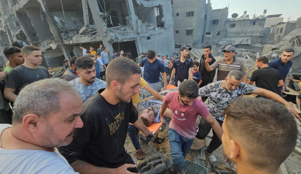 Palestinians evacuate a casualty at the site of Israeli strikes on houses in Jabalia refugee camp in the northern Gaza Strip, October 31, 2023. REUTERS/Anas al-Shareef