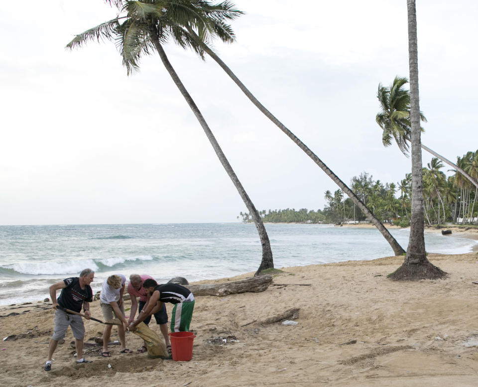 <p>Varias personas hacen sus propios sacos de arena para proteger sus casas del huracán en Las Terrenas, en la República Dominicana (AP Photo/Tatiana Fernandez) </p>