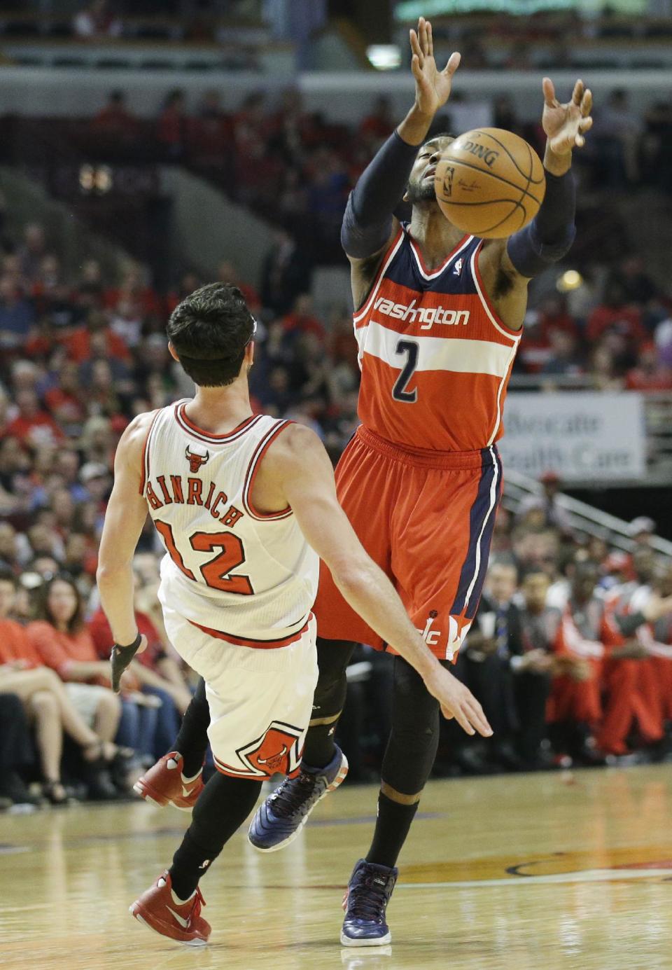 Chicago Bulls guard Kirk Hinrich (12) fouls Washington Wizards guard John Wall (2) during the first half in Game 1 of an opening-round NBA basketball playoff series in Chicago, Sunday, April 20, 2014. (AP Photo/Nam Y. Huh)