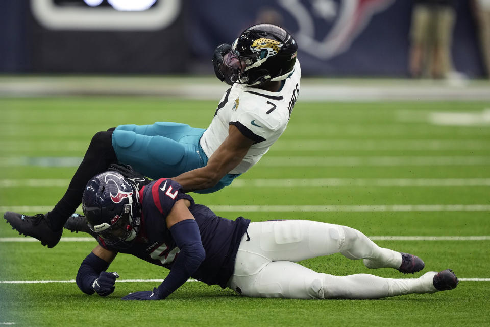 Jacksonville Jaguars wide receiver Zay Jones (7) is hit by Houston Texans safety Jalen Pitre (5) after making a catch for a first down during the second half of an NFL football game in Houston, Sunday, Jan. 1, 2023. (AP Photo/David J. Phillip)