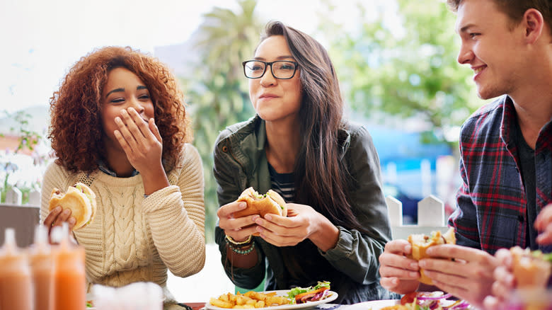 Friends eating burgers at restuarant