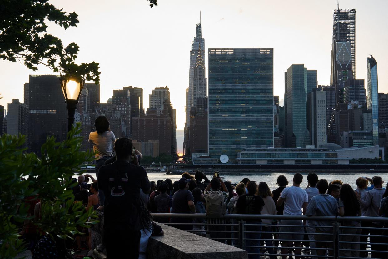 People gather to watch the sunset during a phenomenon known as Manhattanhenge, when the sun lines up with the Manhattan street grid, in Long Island City in the Queens borough of New York City, U.S., May 28, 2024.