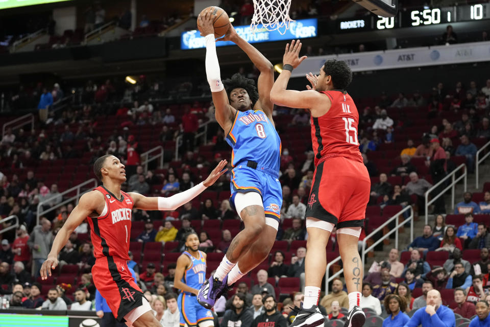 Oklahoma City Thunder forward Jalen Williams (8) drives to the basket as Houston Rockets guard Daishen Nix (15) and forward Jabari Smith Jr., left, defend during the first half of an NBA basketball game, Wednesday, Feb. 1, 2023, in Houston. (AP Photo/Eric Christian Smith)