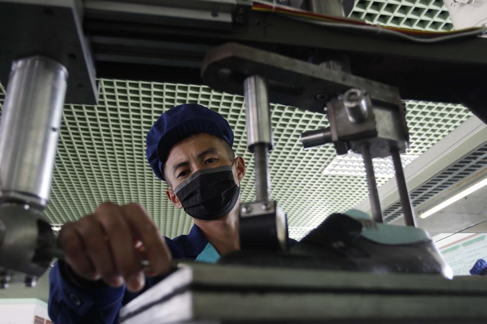 An employee assembles leather shoes at the Wonsan Leather Shoes Factory in Wonsan, Kangwon Province, North Korea, on Oct. 28, 2020. North Korea is staging an “80-day battle,” a propaganda-heavy productivity campaign meant to bolster its internal unity and report greater production in various industry sectors ahead of a ruling party congress in January. (AP Photo/Jon Chol Jin)