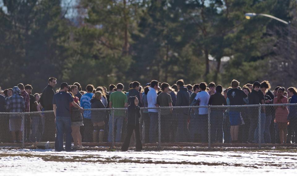 Students gather outside Arapahoe High School, after a student opened fire in the school in Centennial, Colorado December 13, 2013. The student seeking to confront one of his teachers opened fire at the Colorado high school on Friday, wounding at least two classmates before apparently taking his own life, law enforcement officials said. REUTERS/Evan Semon (UNITED STATES - Tags: EDUCATION CRIME LAW)