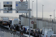 Cars and truck are stopped as French fishermen block the entrance of the Euro Tunnel, in Coquelles, northern France Friday, Nov. 26, 2021. French fishing crews are threatening to block French ports and traffic under the English Channel on Friday to disrupt the flow of goods to the U.K., in a dispute over post-Brexit fishing licenses. (AP Photo/Michel Spingler)