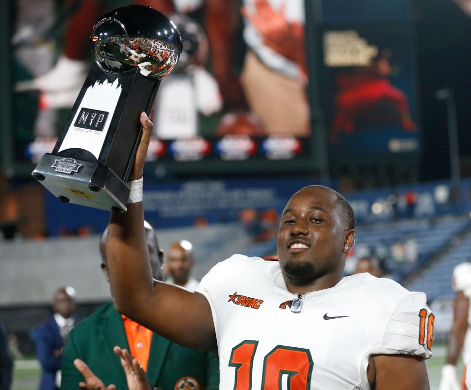 Florida A&M quarterback Daniel Richardson (10) rates the MVP trophy after winning the Cricket MEAC-SWAC Challenge NCAA college football game against Norfolk State in Atlanta on Saturday, Aug. 24, 2024. Florida A&M won 24-23.