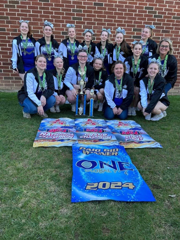 The Warriors cheer squad poses along with their banners denoting the awards won at the National Championship in Hershey, Pa.