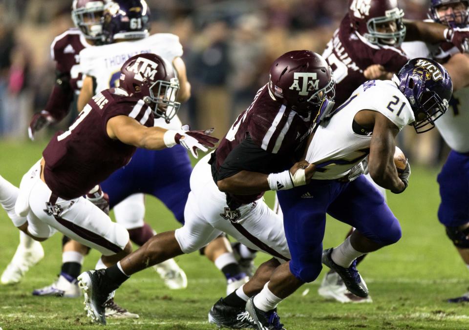 Texas A&M’s Myles Garrett, left, tackles Western Carolina's Detrez Newsome (21) during the first half of an NCAA college football game Saturday, Nov. 14, 2015, in College Station, Texas. Texas A&M defeated Western Carolina 41-17. (AP Photo/Juan DeLeon)