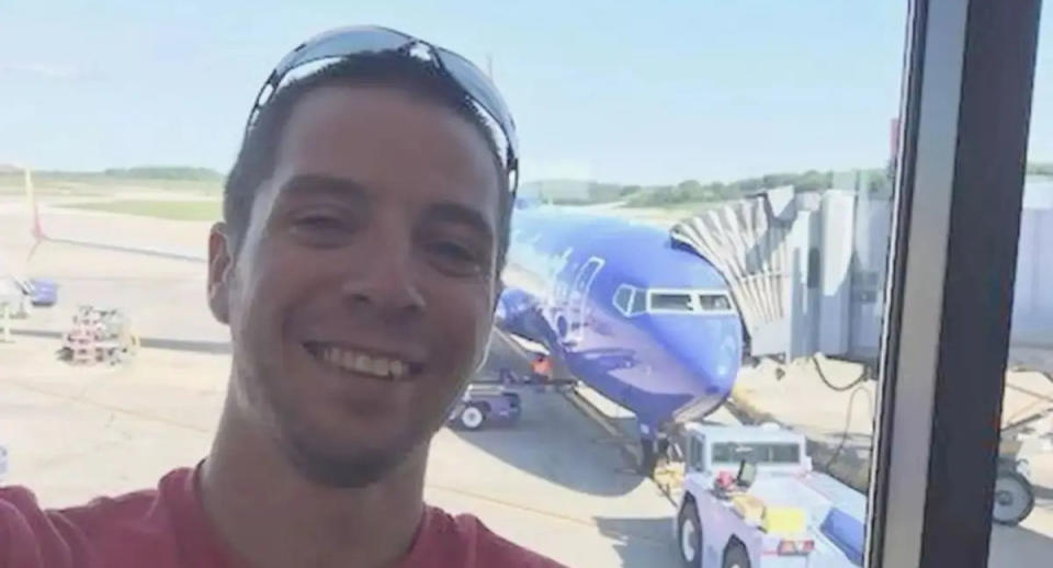 Cory Wayne Patterson takes a selfie in front of a plane.