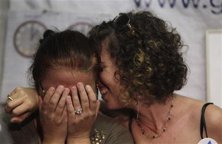 Israelis react to the news that Israel and the Palestinian militant group Hamas had signed a deal for the release of captive Israeli soldier Gilad Shalit, at a protest tent outside the residence of Israel's Prime Minister Benjamin Netanyahu in Jerusalem, October 11, 2011. REUTERS/Ammar Awad