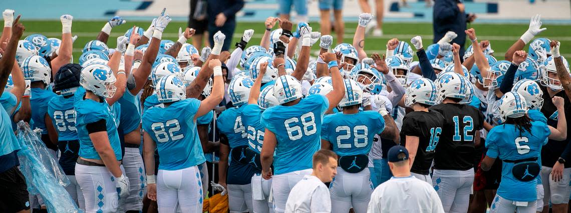 The North Carolina football team huddles around senior Cedric Gray (33) as they begin their open practice and scrimmage on Saturday, March 25, 2023 at Kenan Stadium in Chapel Hill. N.C.
