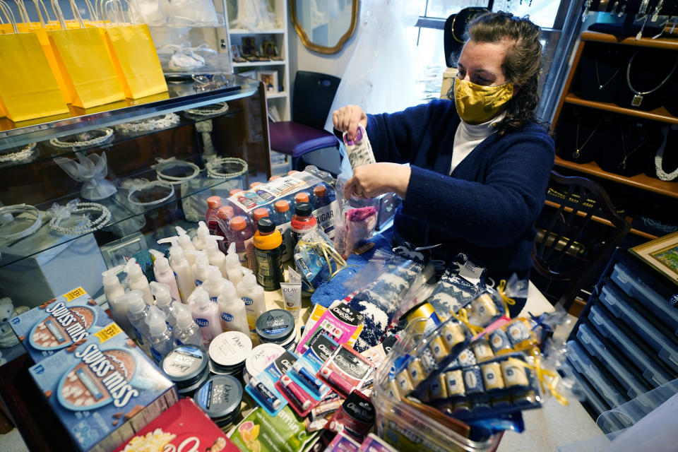 Volunteer Athena Papageorgiou prepares student care packages in her home, Tuesday, Nov. 17, 2020, in Ann Arbor, Mich. A group of parents has come together to help support University of Michigan students while they are sick or quarantining. The group of mostly moms was started and is organized by Sherry Levine of Rye Brook, New York, who's also a mother of a Michigan student. After she spread the word on parent pages on Facebook, local volunteers stepped up to help fulfill student requests by dropping off groceries or supplies. (AP Photo/Carlos Osorio)