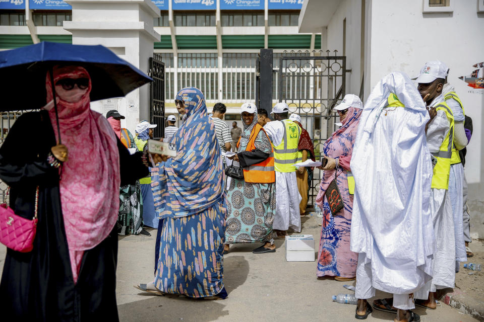 People wait outside a polling station to vote , during the presidential election, in Nouakchott, Mauritania, Saturday, June 29, 2024. Mauritanians are voting for their next president, with the incumbent Mohamed Ould Ghazouani widely expected to win the vote after positioning Mauritania as a strategic ally of the West in a region swept by coups and violence. (AP Photo/Mamsy Elkeihel)