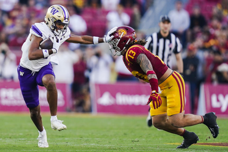 Washington wide receiver Rome Odunze, left, stiff-arms Southern California linebacker Mason Cobb during the first half of an NCAA college football game Saturday, Nov. 4, 2023, in Los Angeles. (AP Photo/Ryan Sun)