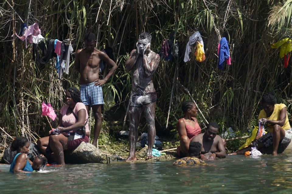 Migrantes haitianos se bañan y lavan su ropa a orillas del río Bravo luego de cruzar a Estados Unidos desde México, el sábado 18 de septiembre de 2021, en Del Rio, Texas. (AP Foto/Eric Gay)