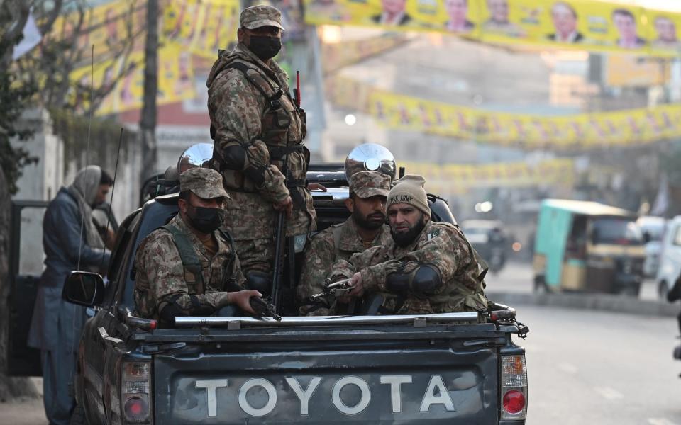 Pakistan army personnel stand guard outside a polling station