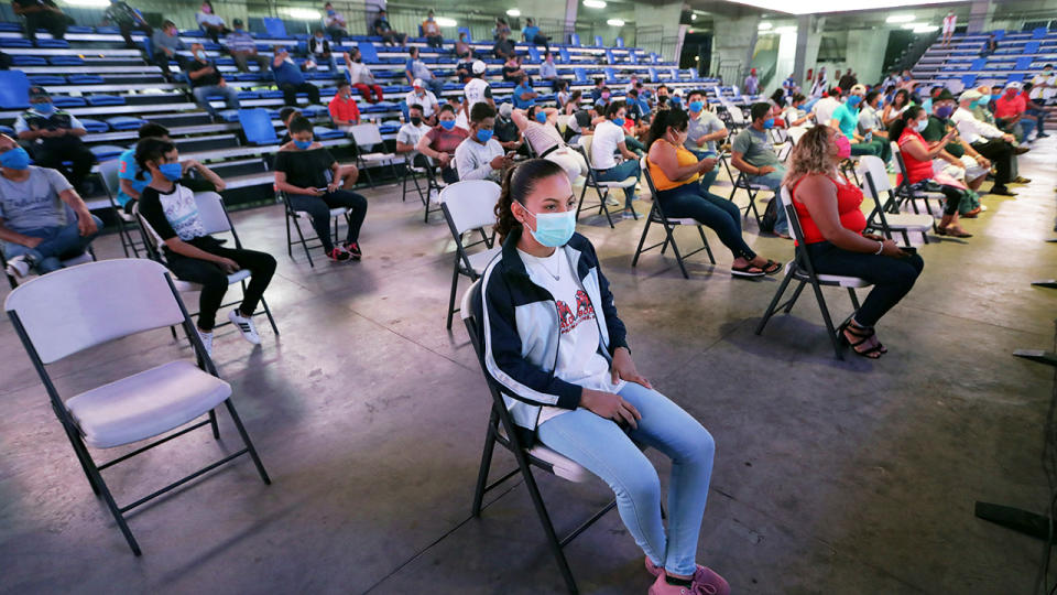 Boxing fans, pictured here wearing face masks and keeping their distance.