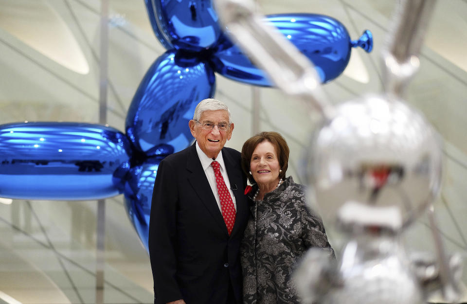 FILE - In this Sept. 16, 2015 file photo, Eli Broad and his wife, Edythe, stand for a photo amid Jeff Koons sculptures at his new museum called "The Broad" in downtown Los Angeles. Eli Broad, the billionaire philanthropist, contemporary art collector and entrepreneur who co-founded homebuilding pioneer Kaufman and Broad Inc. and launched financial services giant SunAmerica Inc., died Friday, April 30, 2021 in Los Angeles. He was 87. (AP Photo/Richard Vogel, File)